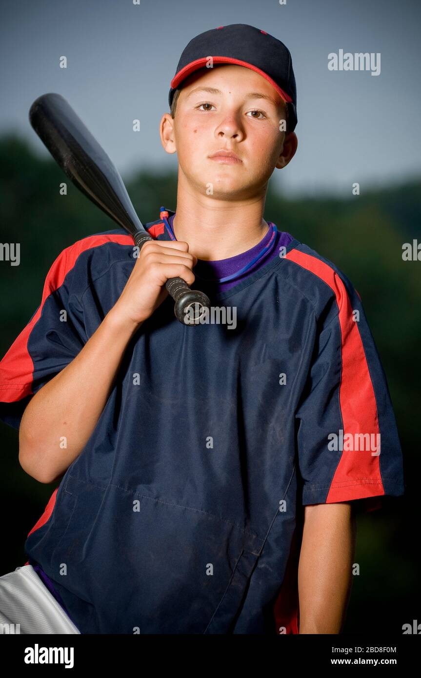 Portrait of a baseball player holding his bat wearing a warm up jacket Stock Photo