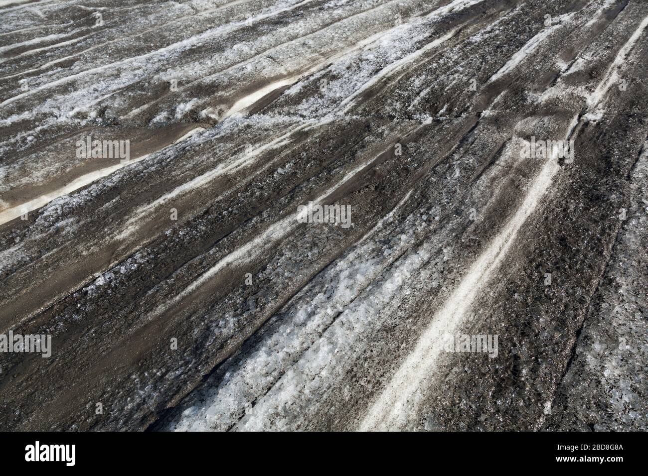 Annual layers of snow accumulation and melt exposed on Snowbird Glacier, Talkeetna Mountains, Alaska. Stock Photo