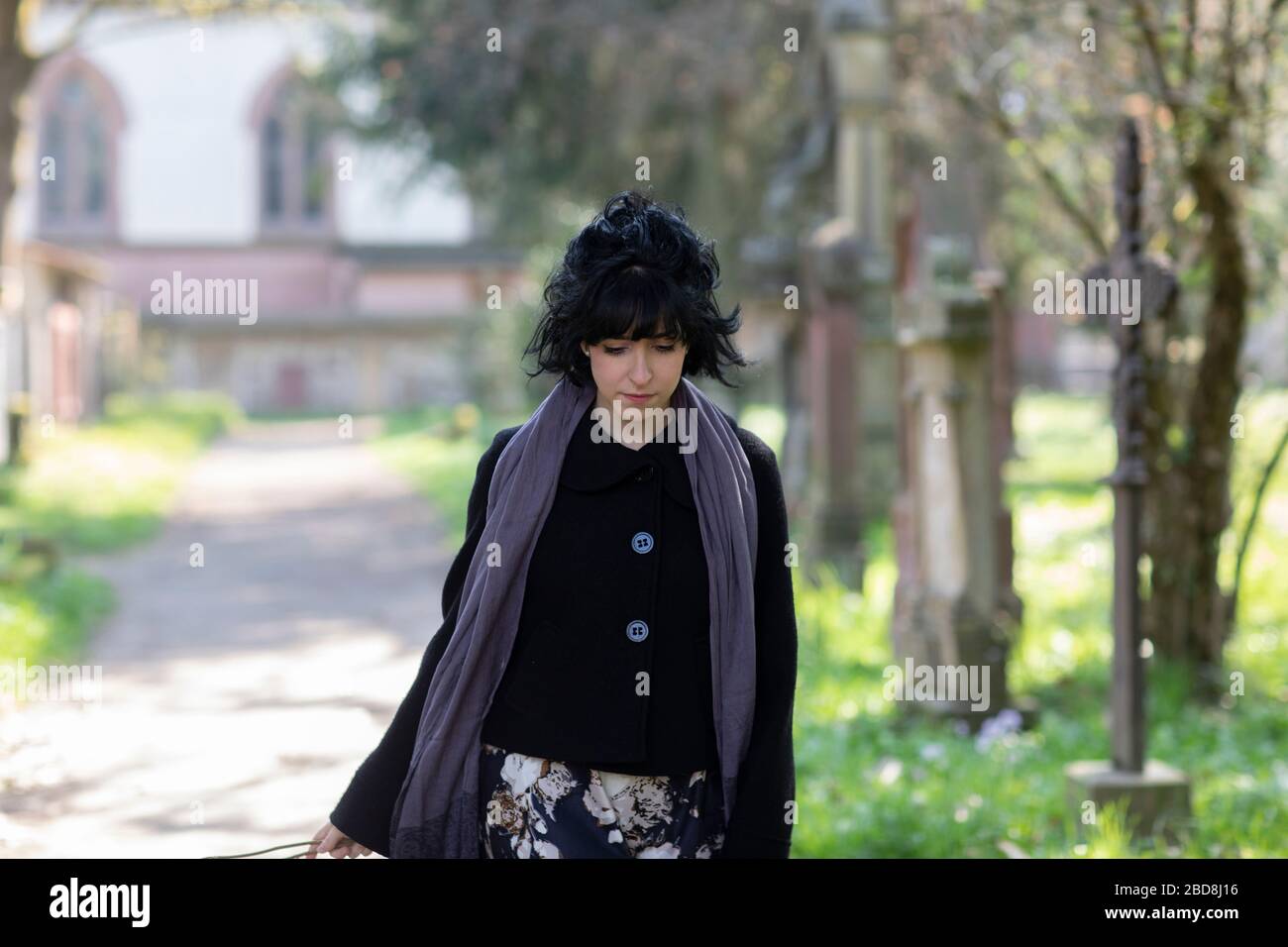 a woman in grief in a graveyard Stock Photo