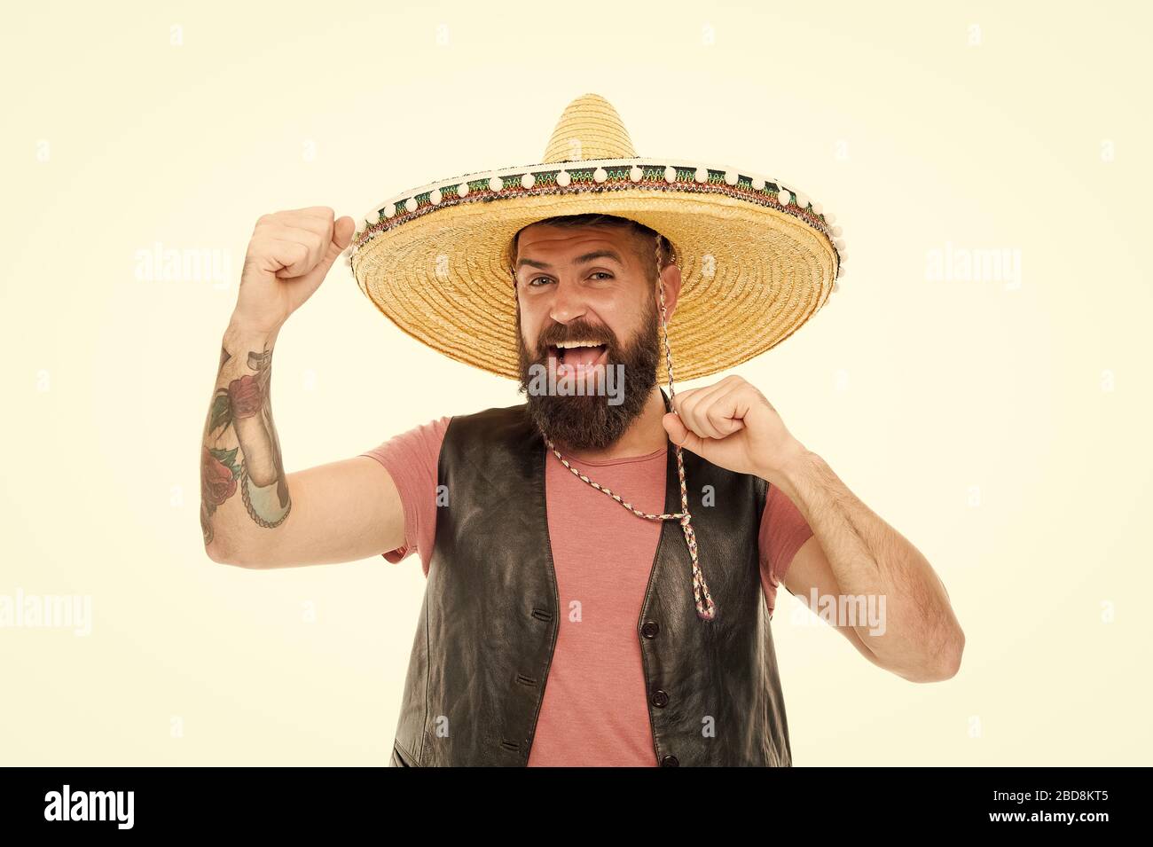 Adding hat to his spanish costume. Bearded man smiling in traditional