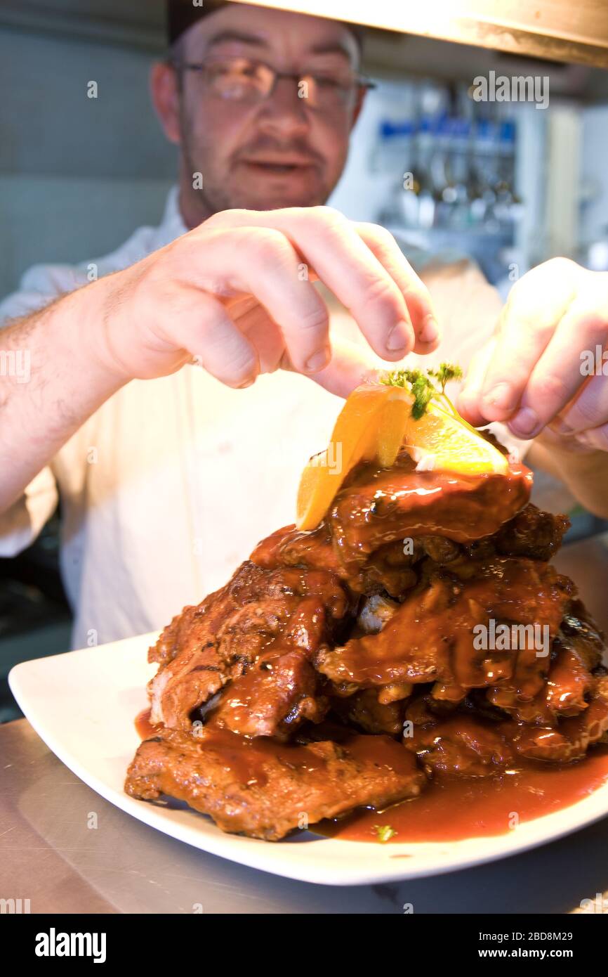 chef putting finishing touch to his dish before serving it Stock Photo