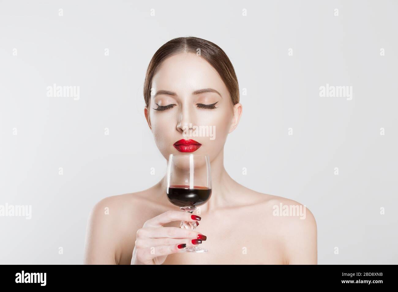 Sommelier. Beautiful young woman smelling feeling aroma drinking with pleasure glass of red wine