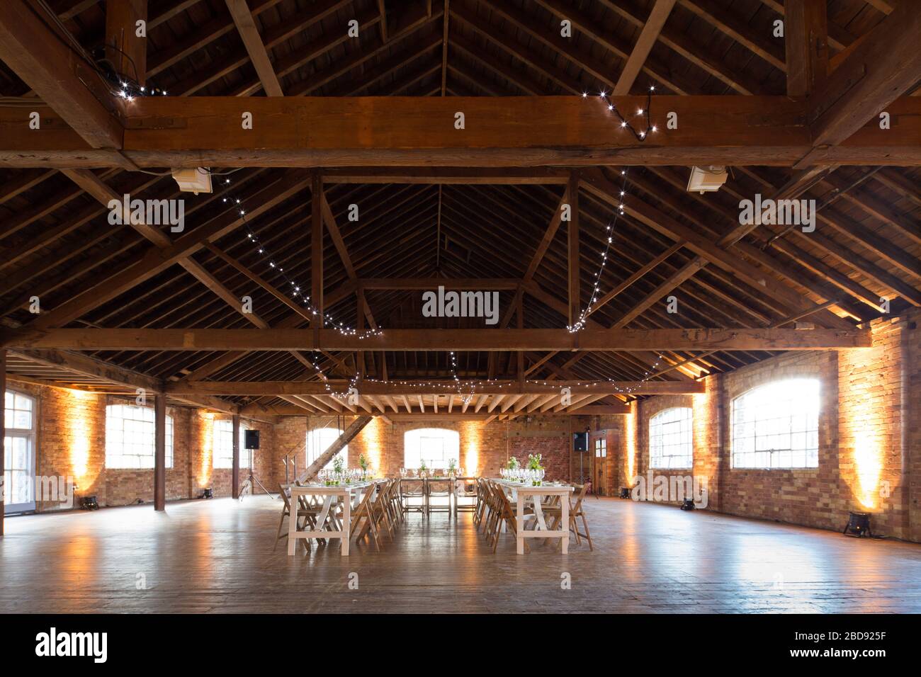 wedding room with a wooden beam ceiling and table set up for banquet Stock Photo
