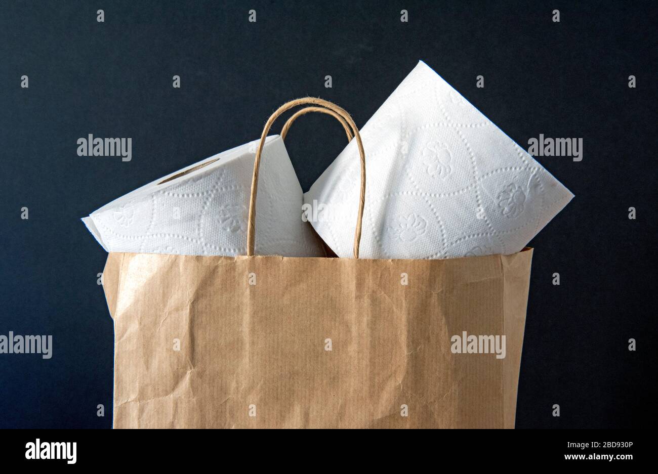 Recycled toilet rolls paper loose in brown paper carrier bag against black background. Zero waste concept Stock Photo