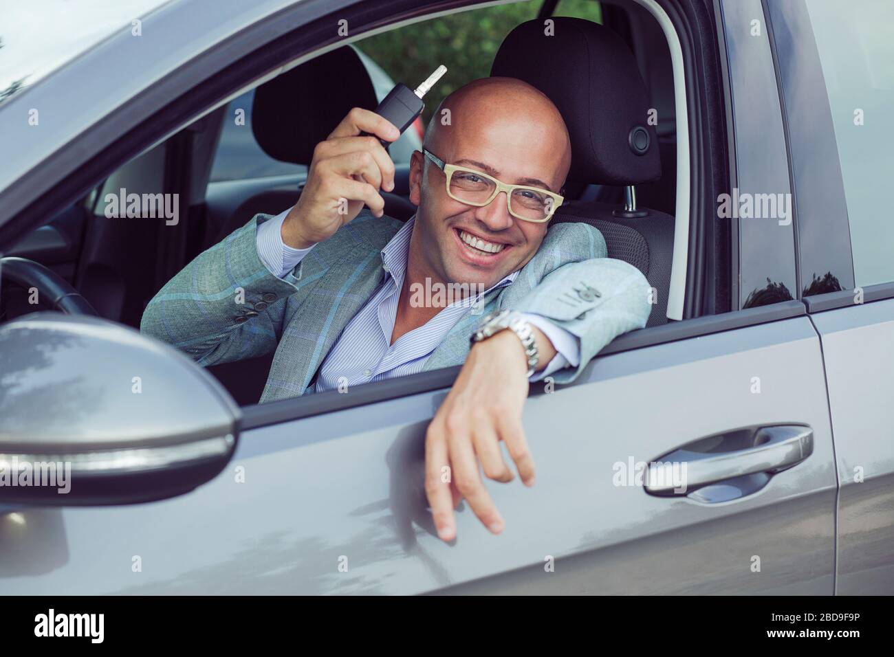 Handsome business man male holding car keys in hand showing his new car ...