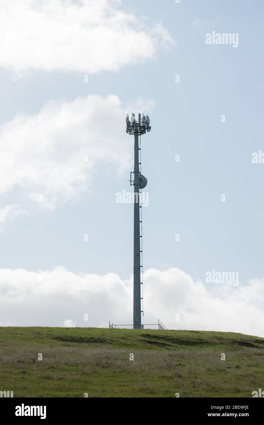 Mobile phone cellular tower on grass with sky and clouds behind, located in Inverloch Victoria Australia Stock Photo