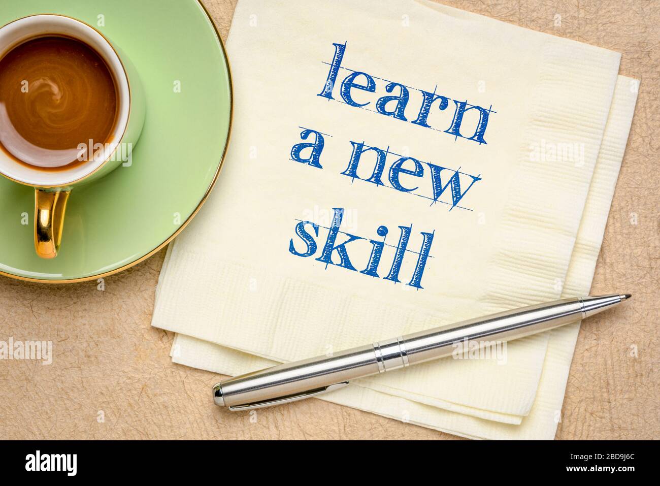 learn a new skill motivational note - handwriting on a napkin with a cup of coffee, personal development and growth concept Stock Photo