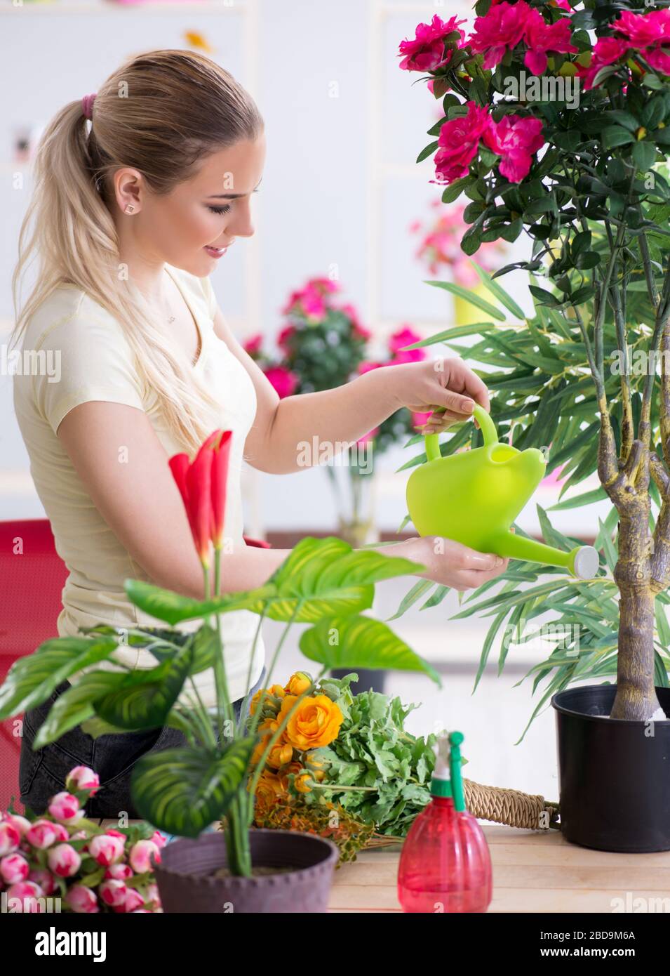 The young woman watering plants in her garden Stock Photo - Alamy