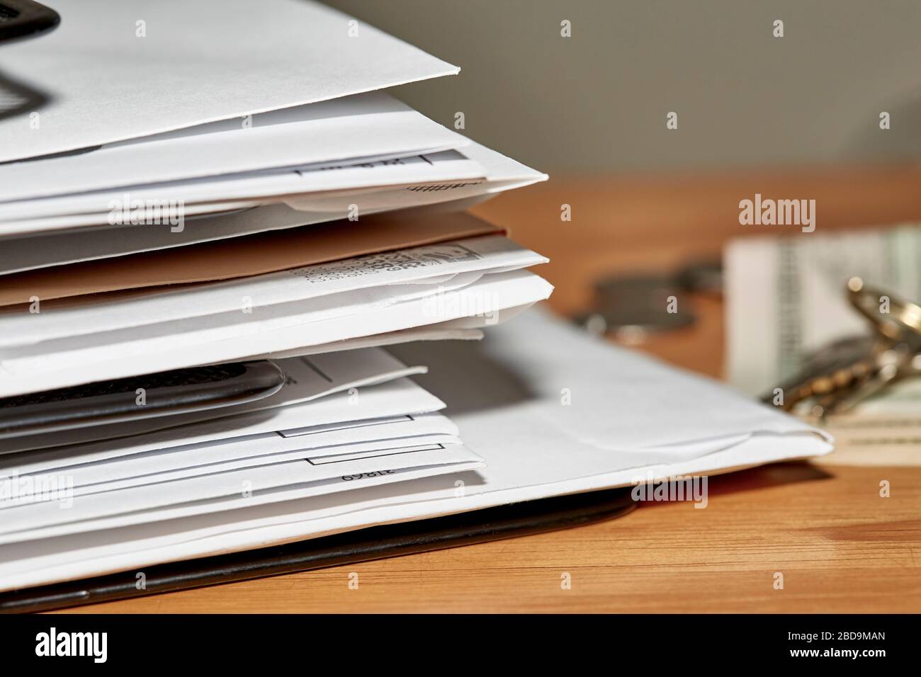 Stack of open and unopened envelopes in a desk organizer with keys