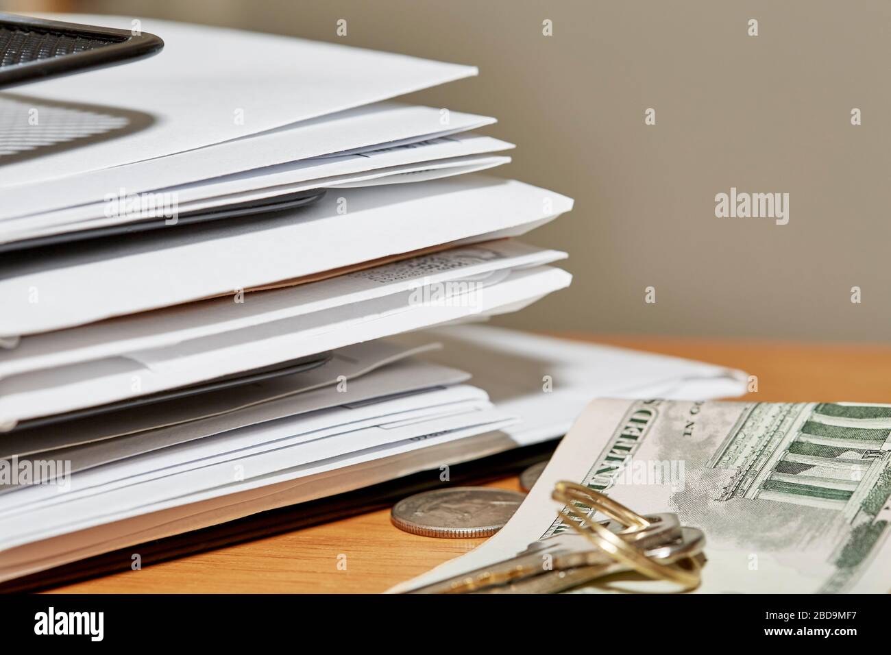 Stack of open and unopened envelopes in a desk organizer with keys