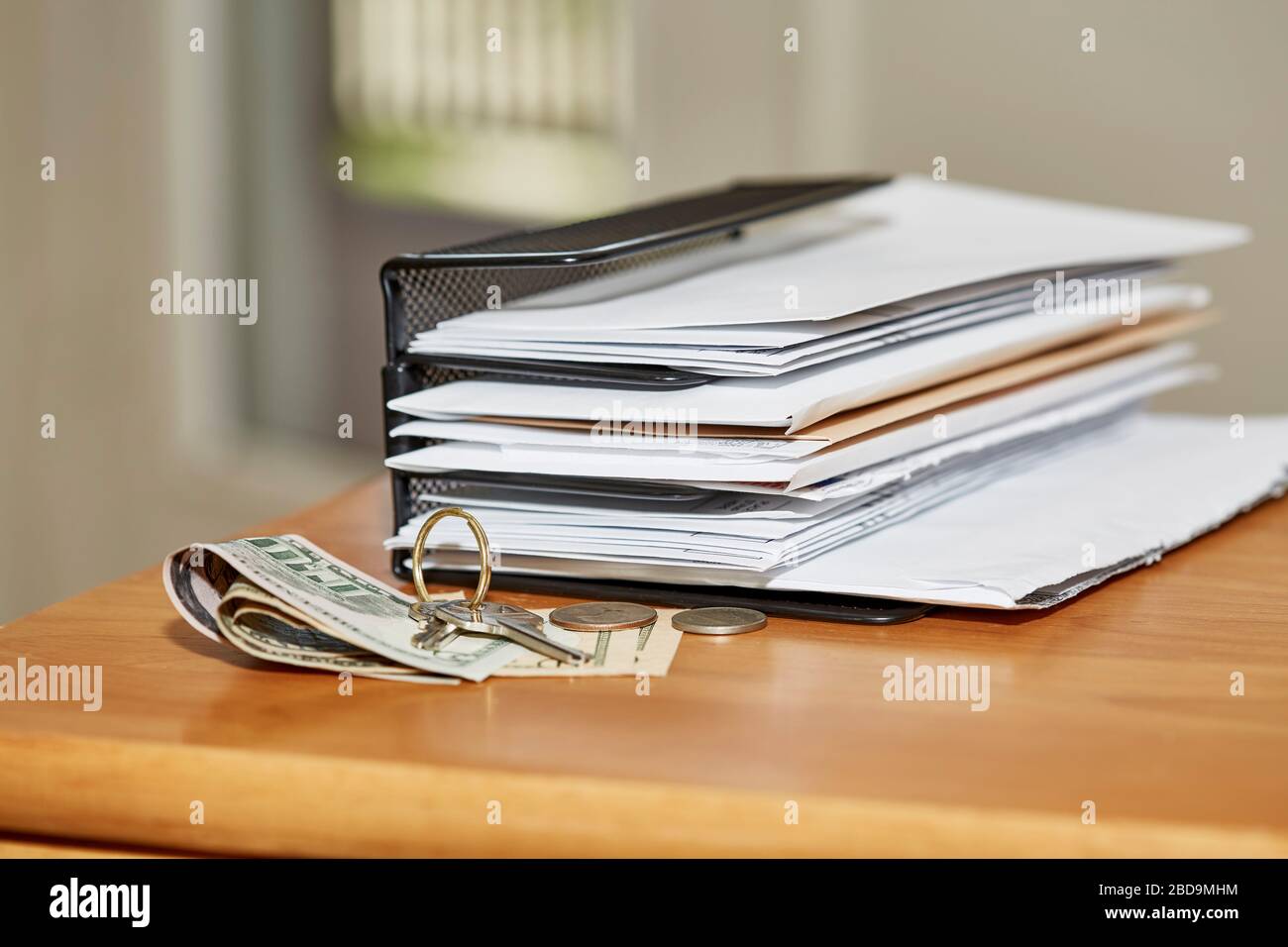 Stack of open and unopened envelopes in a desk organizer with keys