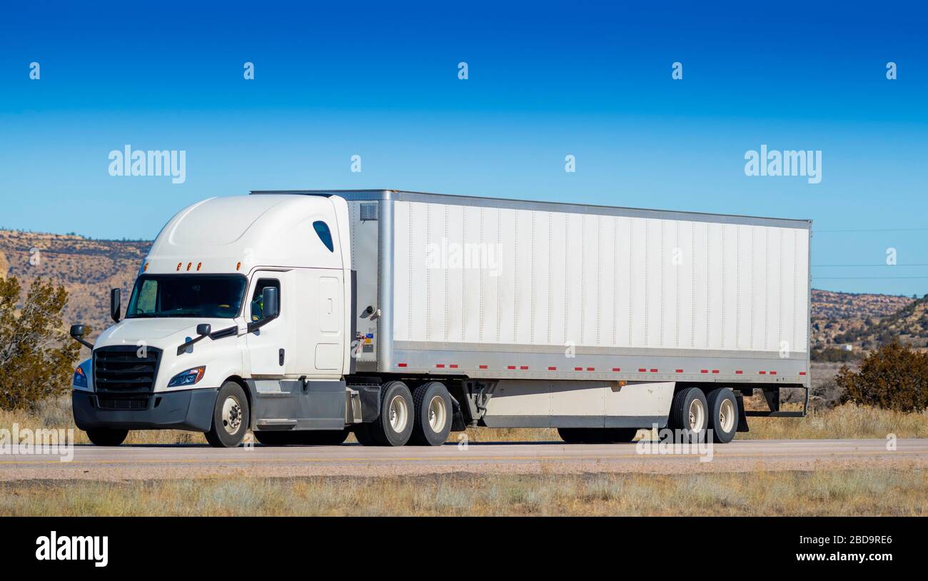 Eighteen wheel big rig tractor with trailer on highway. Trucking industry Stock Photo