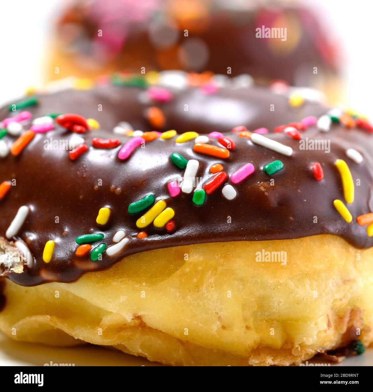Chocolate glazed donuts with sprinkles on a white background Stock