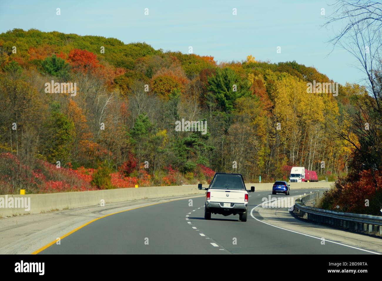 Ontario, Canada - October 28, 2019 - The view of the traffic on Route 401 highway overlooking the sunning colors of fall foliage Stock Photo