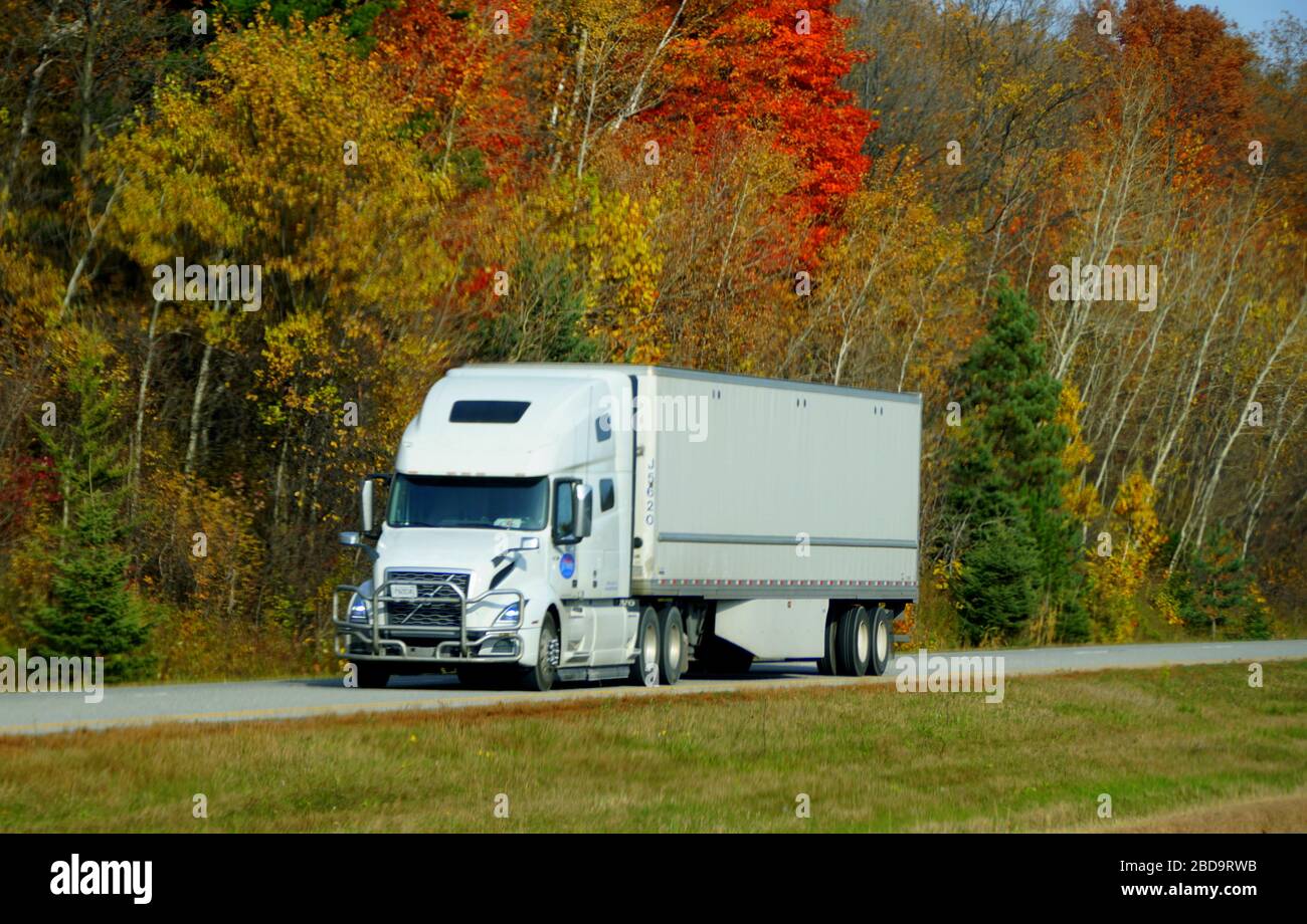 Ontario, Canada - October 27, 2019 - A large white truck on the Route 401 highway with stunning colors of fall foliage Stock Photo