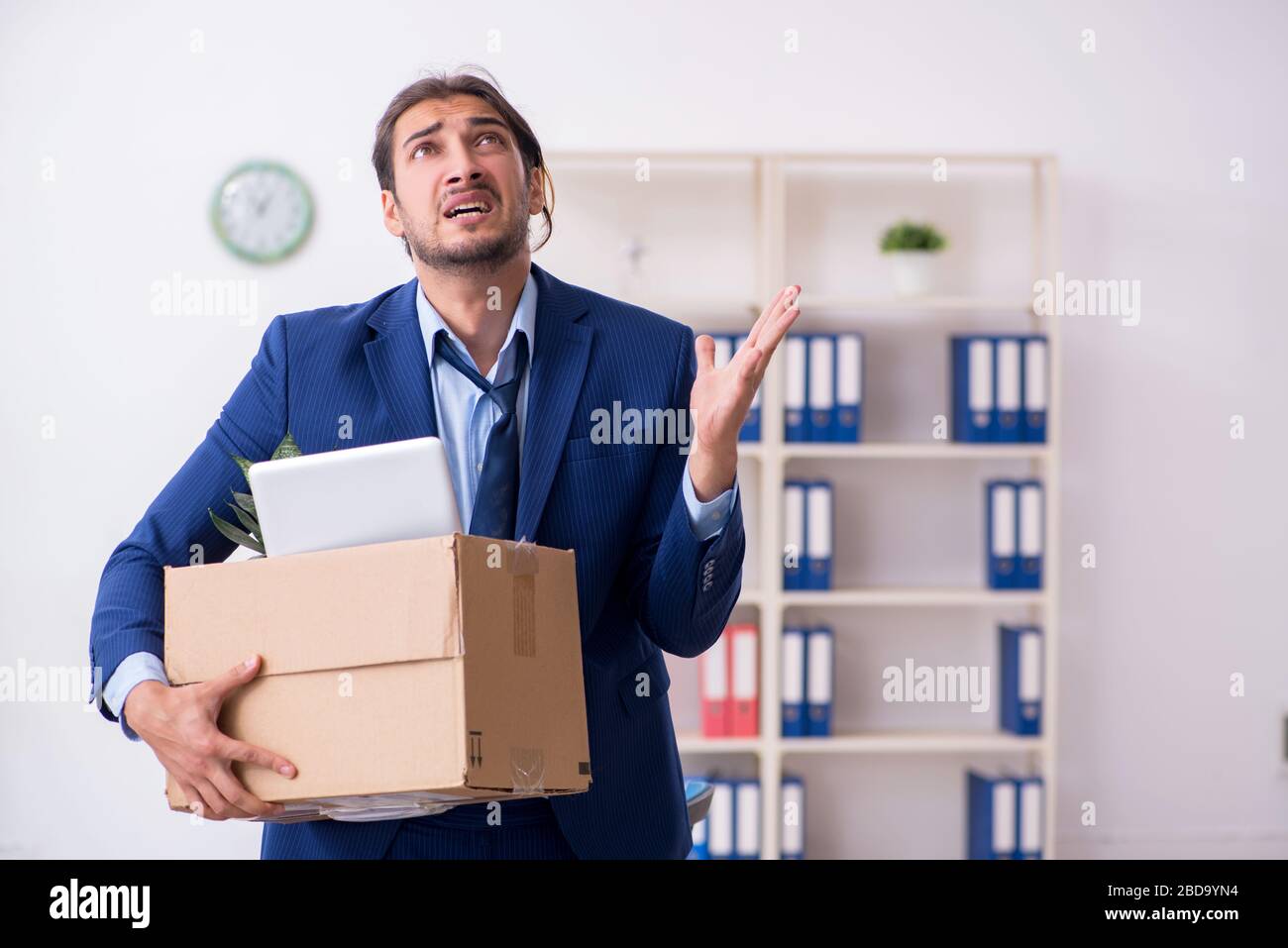 Young man being fired from his workplace Stock Photo - Alamy