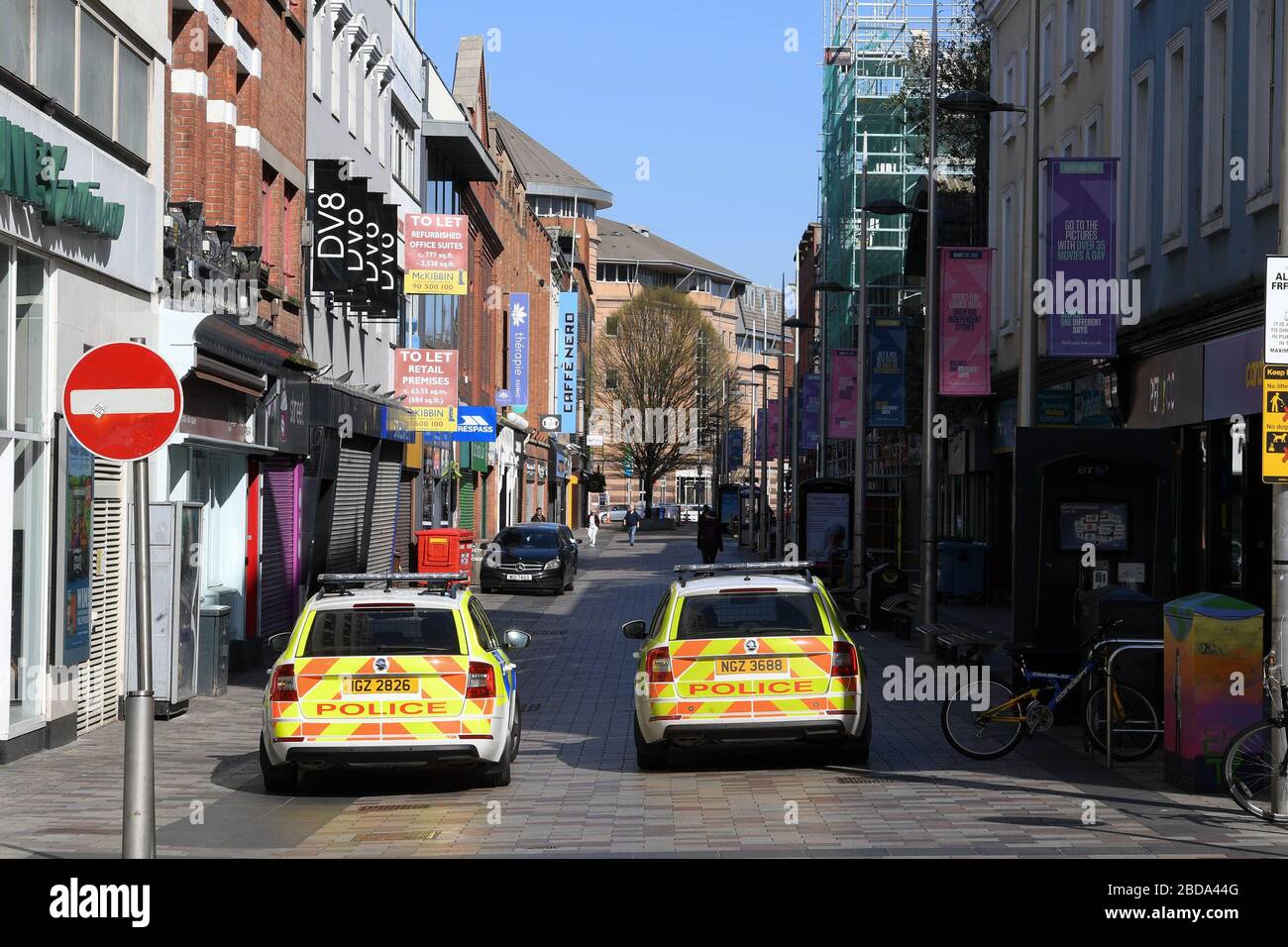 Shuttered stores and police patrols on Ann Street in Belfast, as the UK continues in lockdown to help curb the spread of the coronavirus. Stock Photo