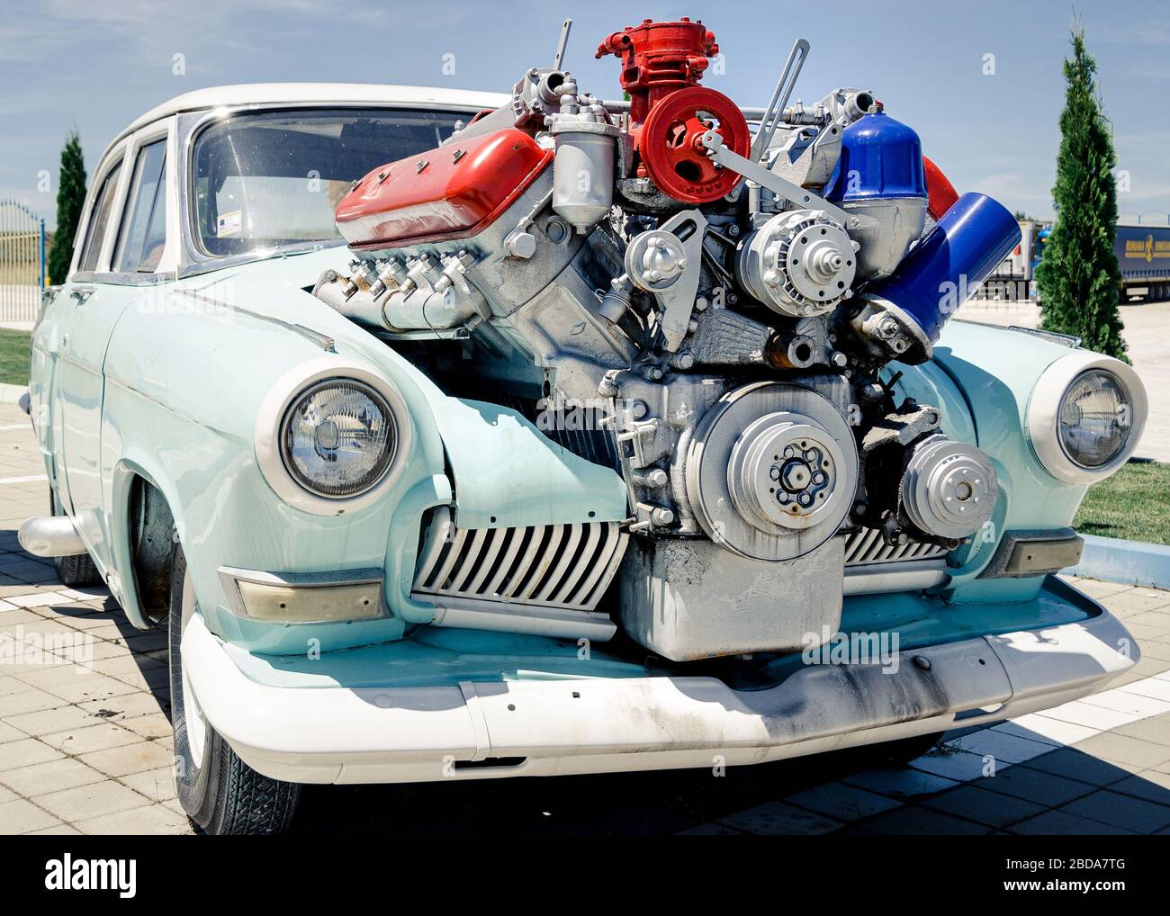 Medium shot of old car with oversized mounted engine powerful concept or over enthusiastic conversion concept Stock Photo