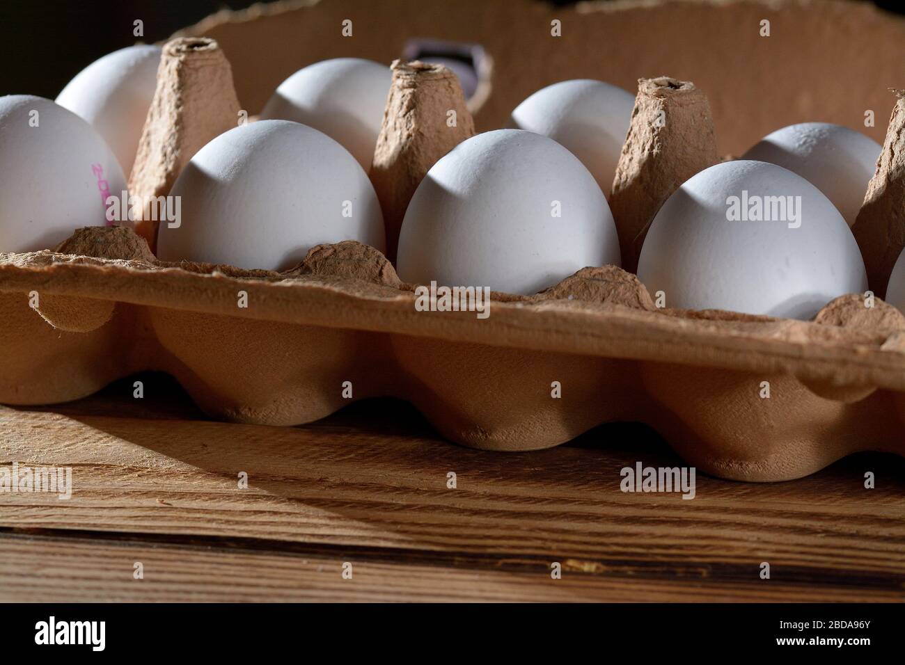 White chicken eggs in the egg carton on wooden surface Stock Photo - Alamy