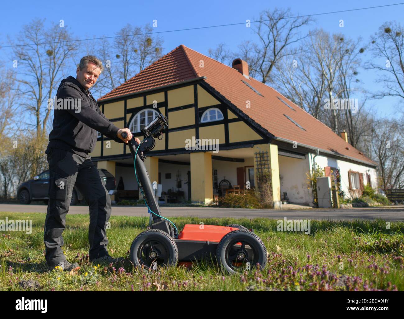 06 April 2020, Brandenburg, Kunersdorf: Joachim Kozlowski, reshuffler of the Volksbund Deutsche Kriegsgräberfürsorge, is standing with a ground radar on a meadow in front of the Damkrughaus. 75 years ago, the Oderbruch became the most destroyed area in Germany. For four days the bloody battle for the Seelower heights raged here: The Red Army, on its advance towards Berlin, met with fierce resistance from the German Wehrmacht. Photo: Patrick Pleul/dpa-Zentralbild/ZB Stock Photo
