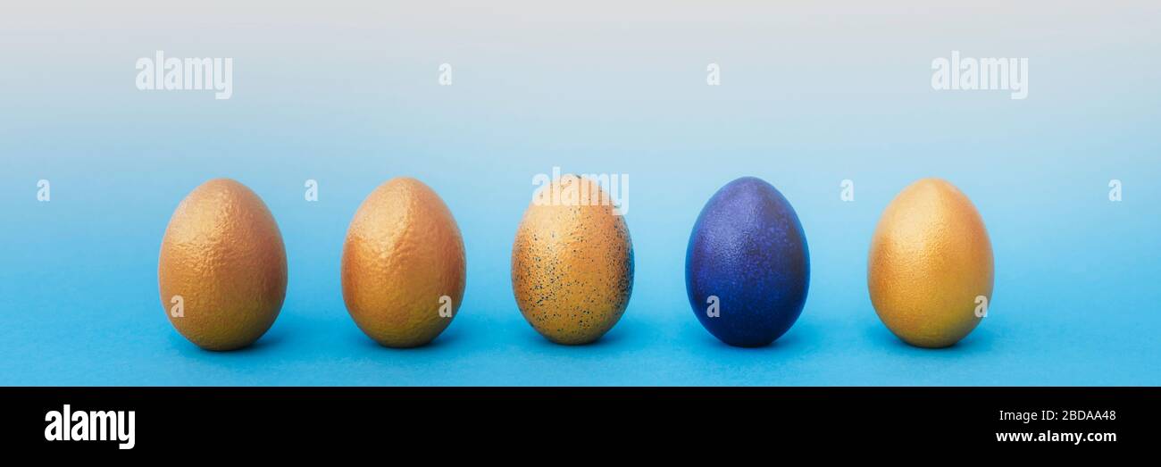 Golden and blue easter eggs on blue pastel background. Easter concept. Place for text. Banner. Stock Photo