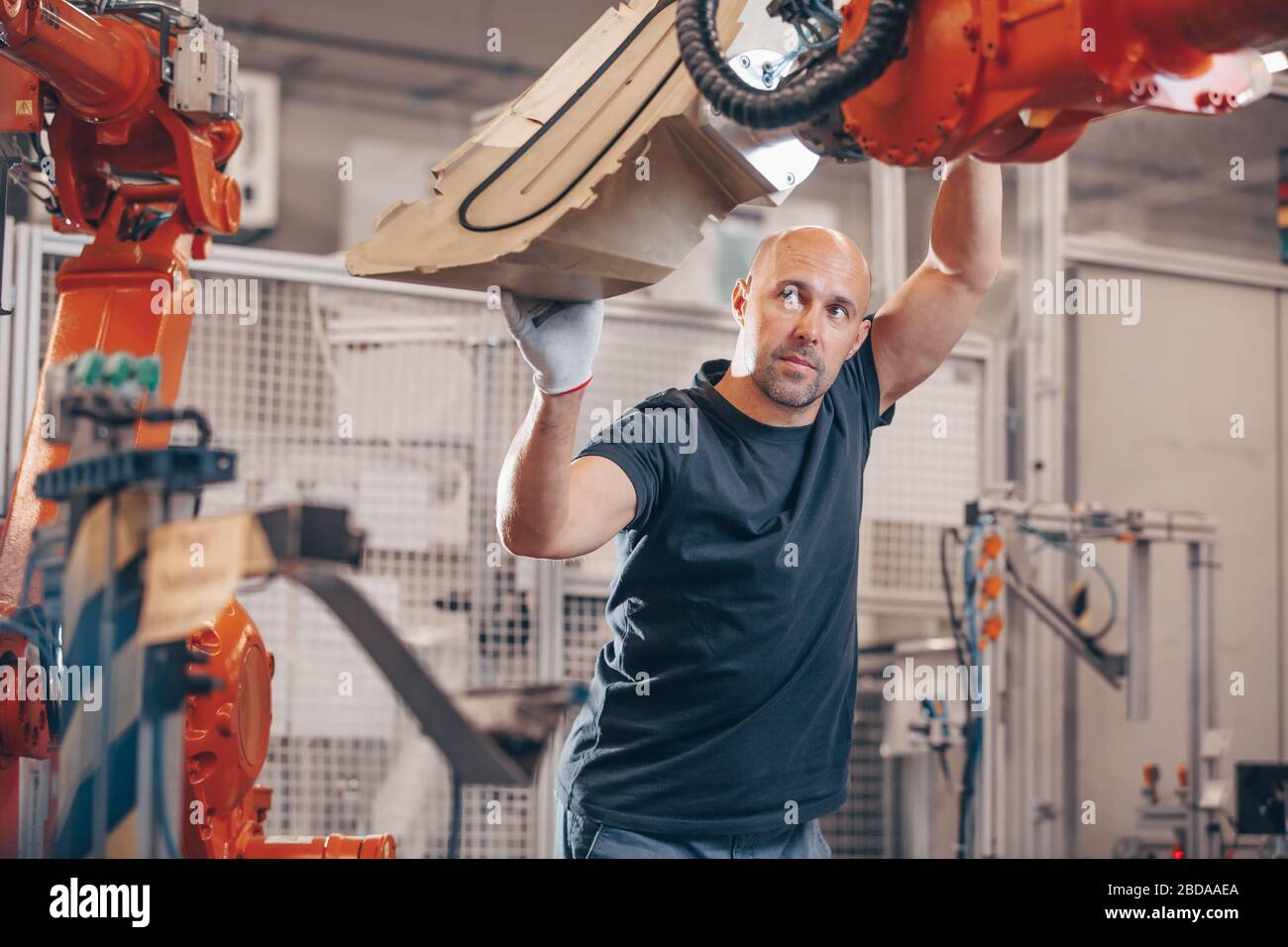 Engineer setting up automatic robot arm for production in automotive, industry factory, industrial concept Stock Photo