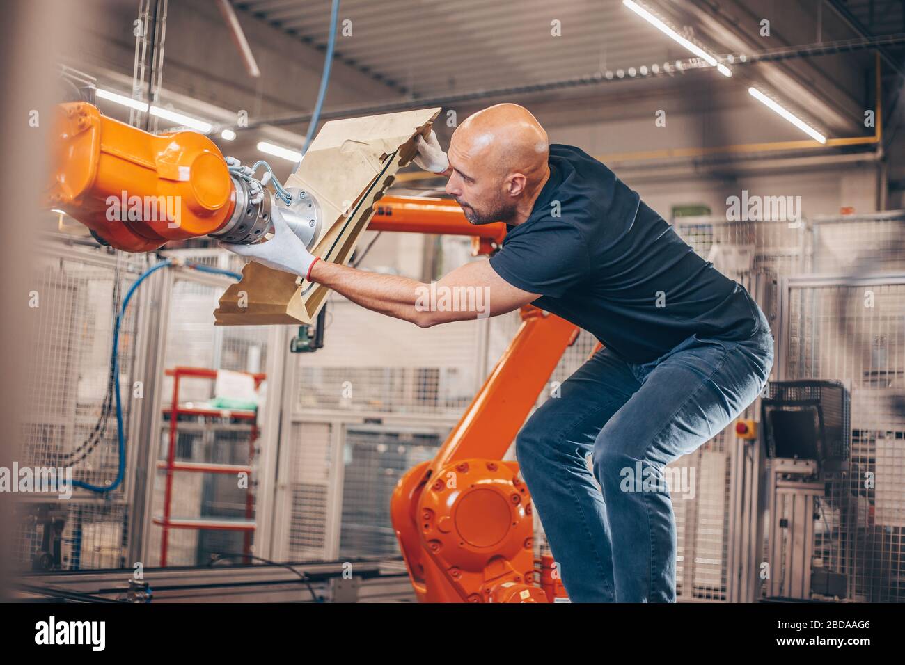 Engineer setting up automatic robot arm for production in automotive, industry factory, industrial concept Stock Photo
