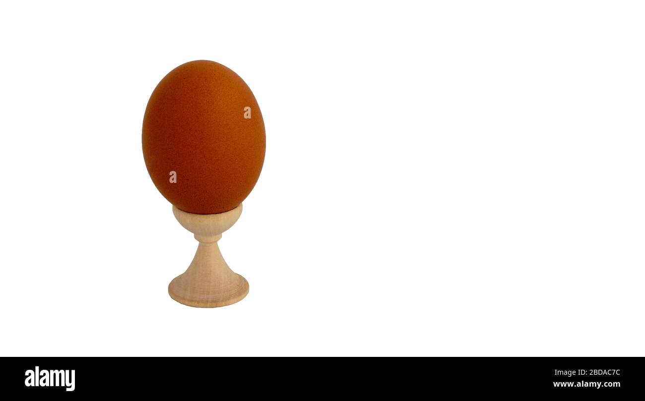 Egg standing on cup, on a soft white background Stock Photo