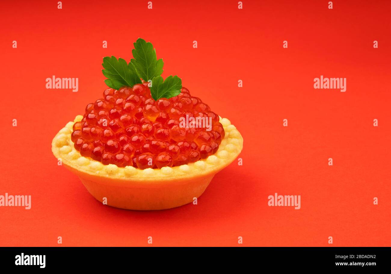 Tartlet with red caviar isolated on red background Stock Photo