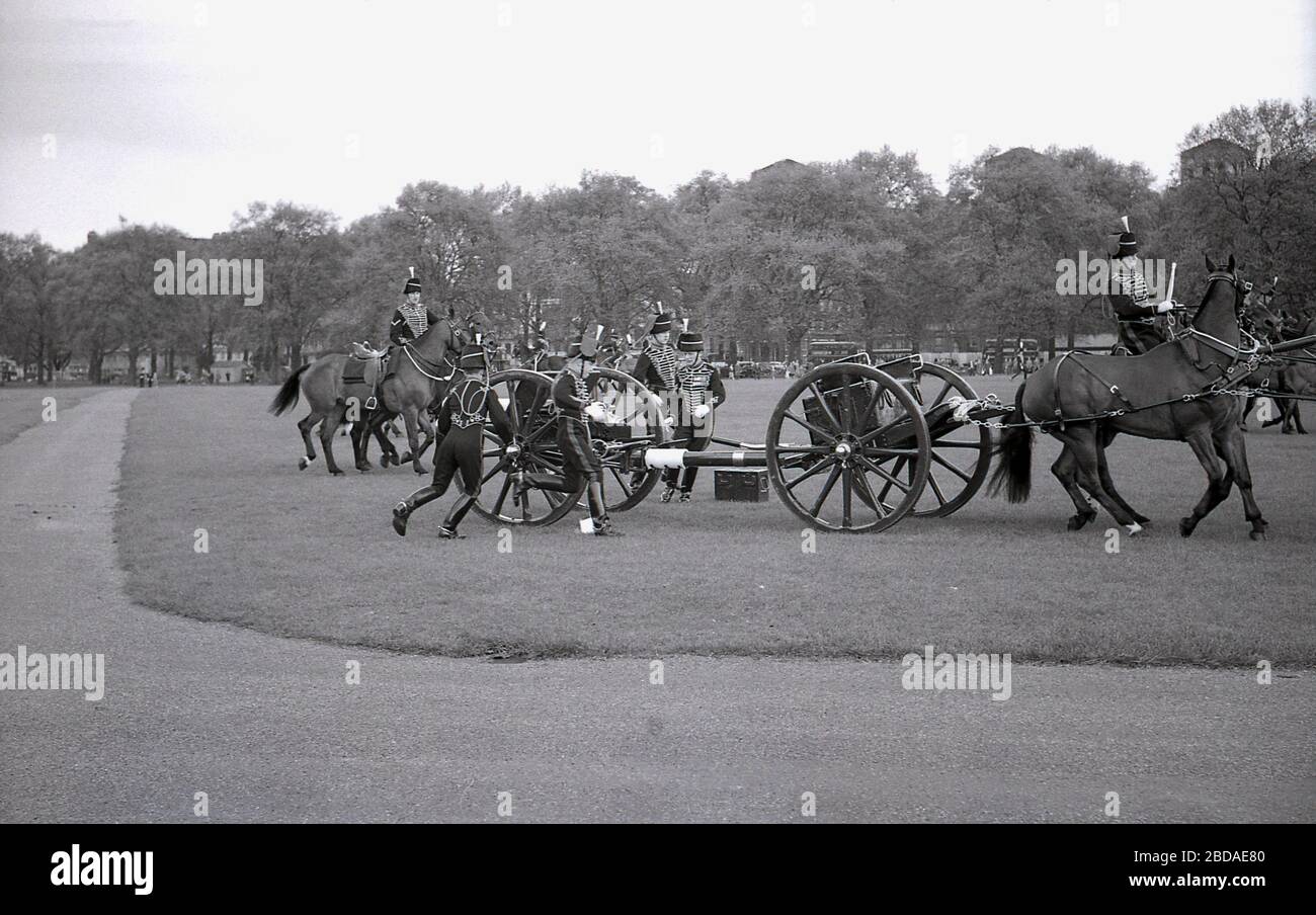 1960s, historical, horse riders moving guns into position for a Royal gun Salute at Green Park near Buckingham Palace, Westminster, London, England. Gun salutes mark special royal occasions including the Queen's birthday and are a tradition display of British pageantry. Stock Photo