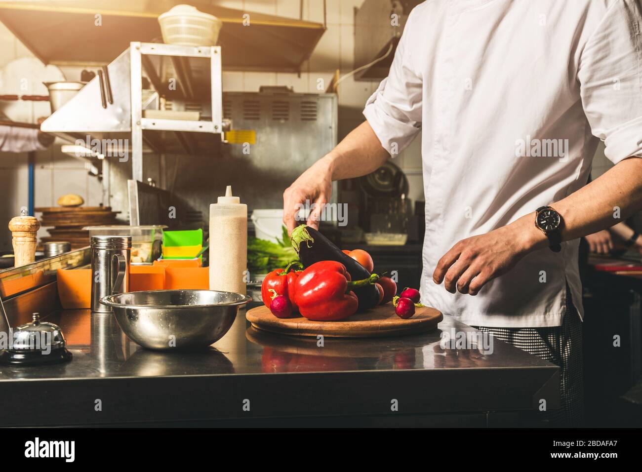 Professional Chef Cooking In The Kitchen Restaurant At The Hotel Preparing Dinner A Cook In An Apron Makes A Salad Of Vegetables And Pizza Stock Photo Alamy