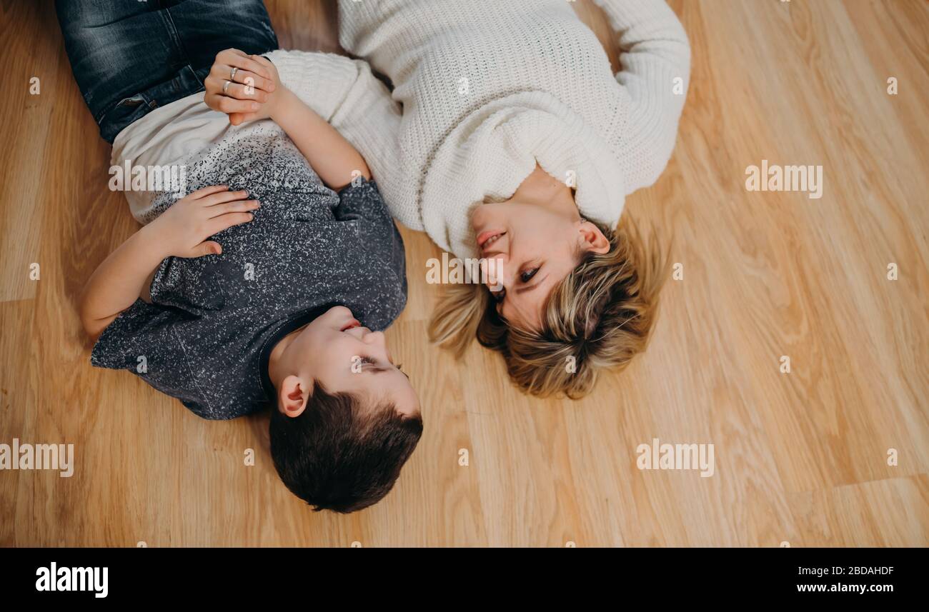 Mother and son are lying on the floor upside down. Companionship Stock Photo