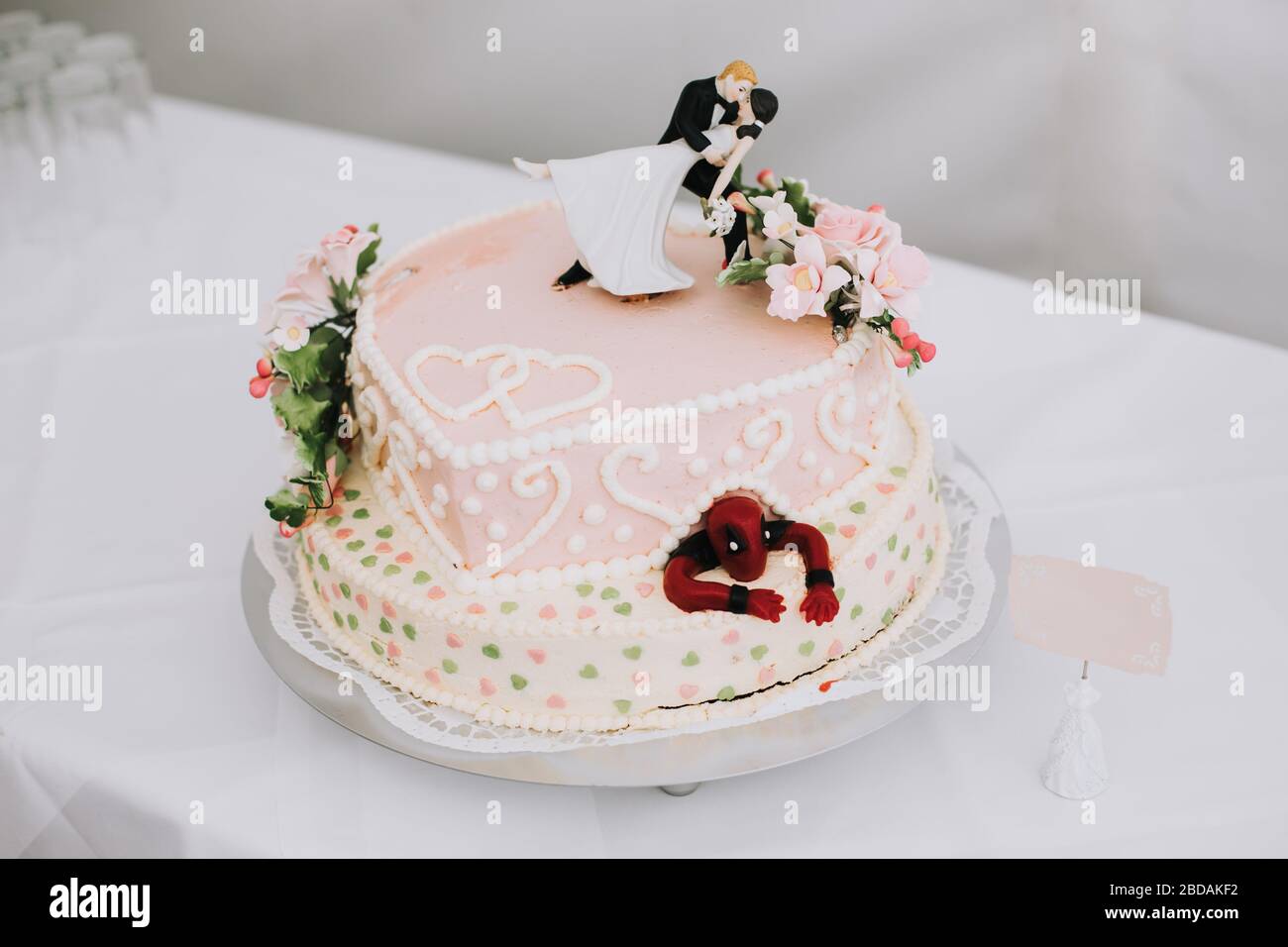 elegant wedding cake with vintage bride and groom sign and batman toy Stock Photo