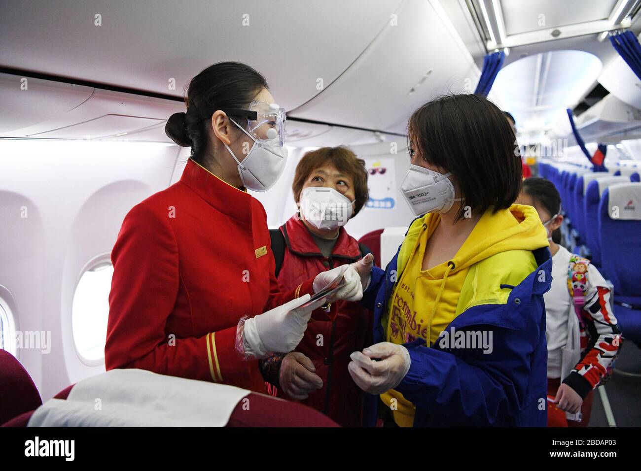 Shenzhen, China's Guangdong Province. 8th Apr, 2020. A stewardess talks with passengers on flight ZH9127 of Shenzhen Airlines at the Baoan International Airport in Shenzhen, south China's Guangdong Province, April 8, 2020. Flight ZH9127 was the first flying from Shenzhen to Wuhan, after Wuhan, capital of central China's Hubei Province, lifted outbound travel restrictions from Wednesday following almost 11 weeks of lockdown to stem the spread of COVID-19. Credit: Liang Xu/Xinhua/Alamy Live News Stock Photo