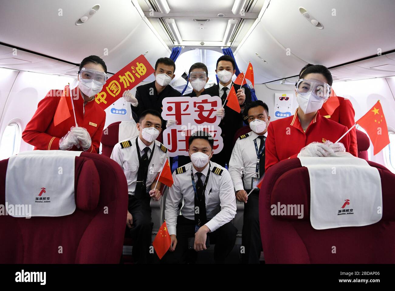 Shenzhen, China's Guangdong Province. 8th Apr, 2020. Crew members pose for a photo on flight ZH9127 of Shenzhen Airlines at the Baoan International Airport in Shenzhen, south China's Guangdong Province, April 8, 2020. Flight ZH9127 was the first flying from Shenzhen to Wuhan, after Wuhan, capital of central China's Hubei Province, lifted outbound travel restrictions from Wednesday following almost 11 weeks of lockdown to stem the spread of COVID-19. Credit: Liang Xu/Xinhua/Alamy Live News Stock Photo