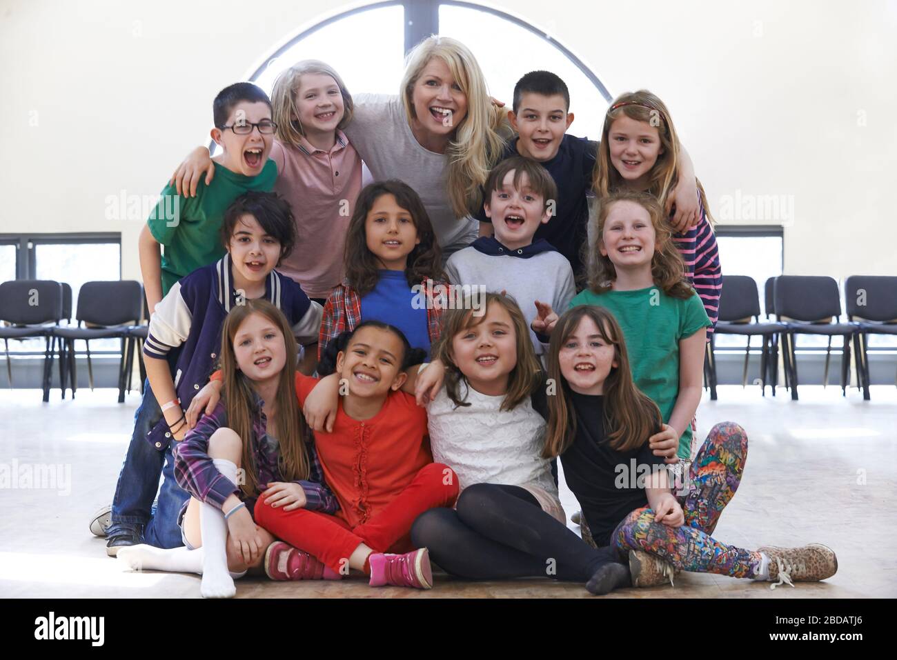 Portrait Of Group Of Children With Teacher Enjoying Drama Workshop Together Stock Photo