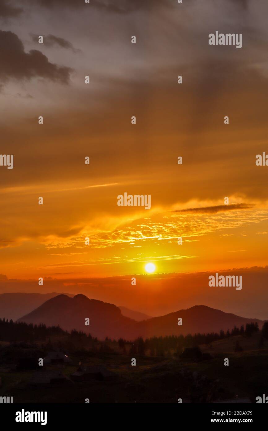 Breathtaking sunrise in Big Pasture Plateau with colorful sky and mountains silhouettes. Sunrise in Velika Planina, Slovenia. Stock Photo