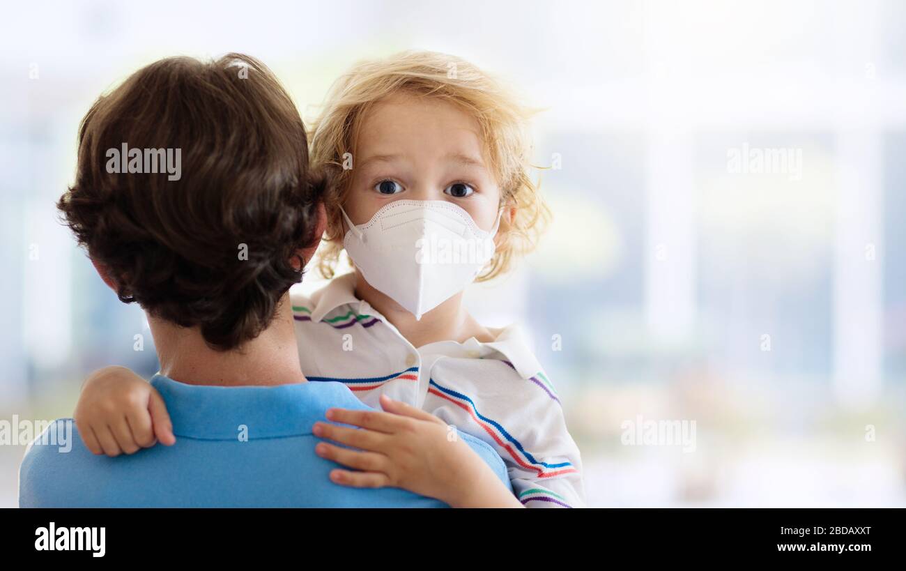 Family with kids in face mask in shopping mall or airport. Father and child wear facemask during coronavirus and flu outbreak. Virus and illness prote Stock Photo