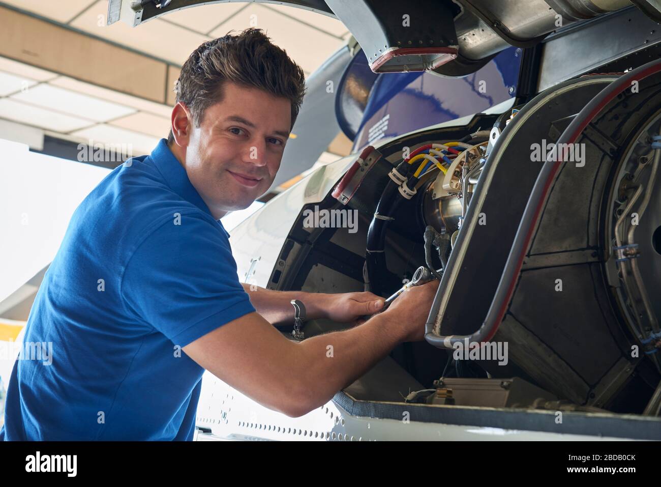 Portrait Of Male Aero Engineer Working On Helicopter In Hangar Stock Photo