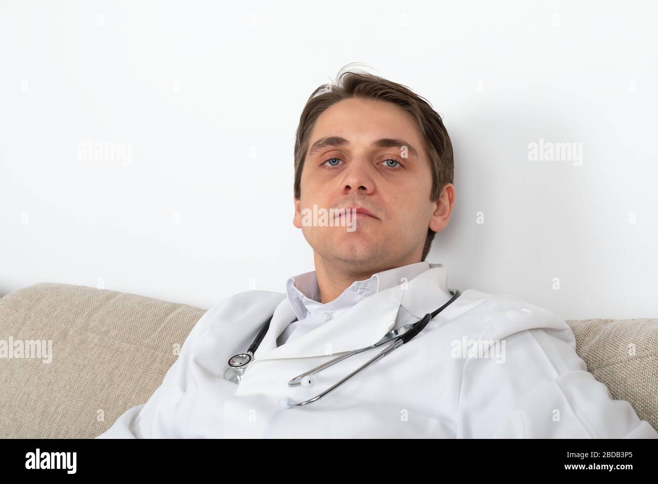 Handsome medical doctor relaxing on the sofa at the office Stock Photo Alamy