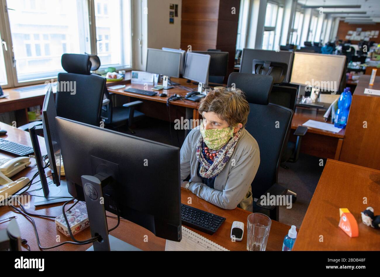 Journalist of Czech News Agency Alice Sterbova  with cloth mask works in empty newsroom in Prague, Czech Republic, March 25, 2020. The most employees Stock Photo