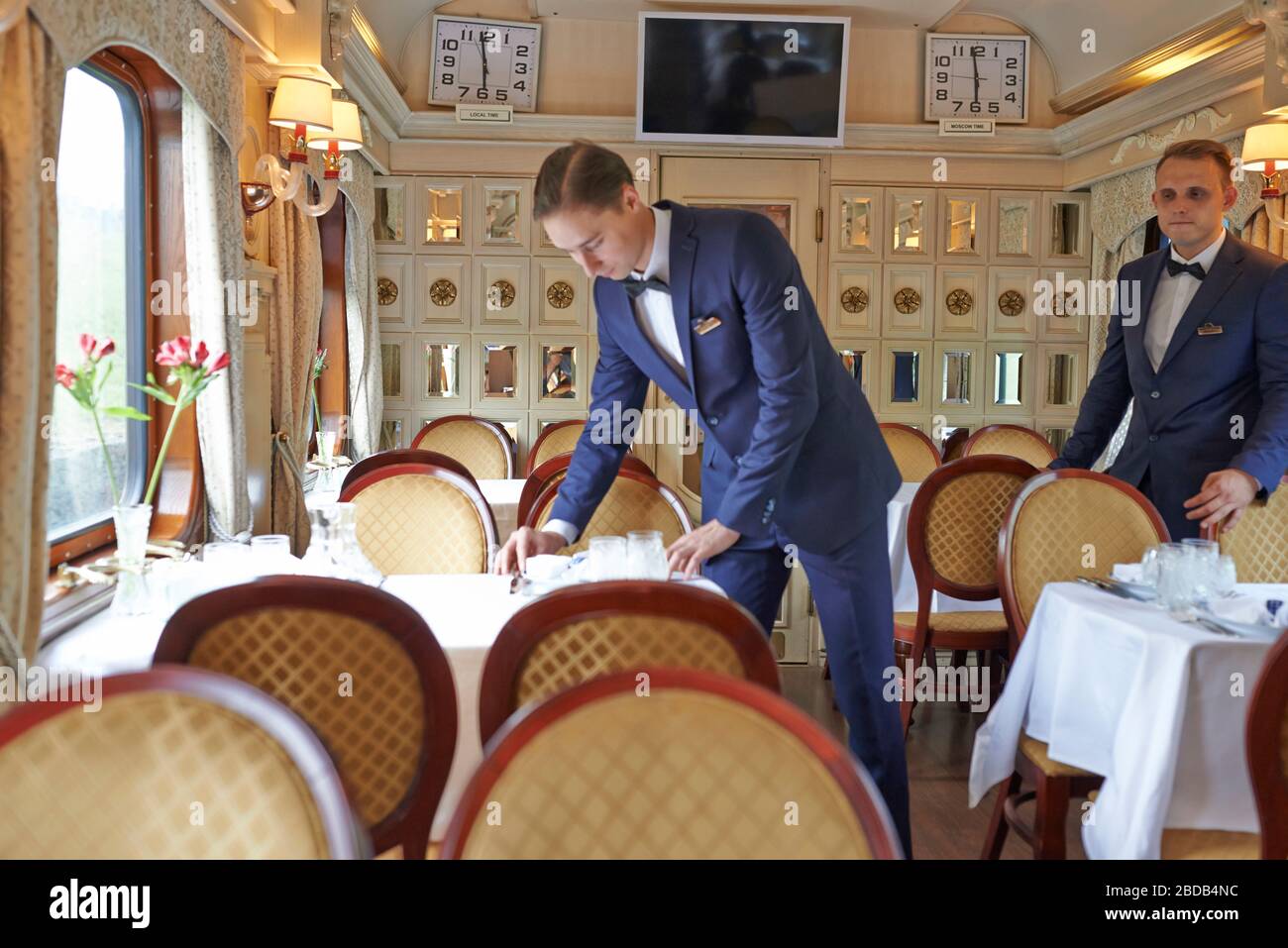 Waiters at work in the restaurant car of the train; food service