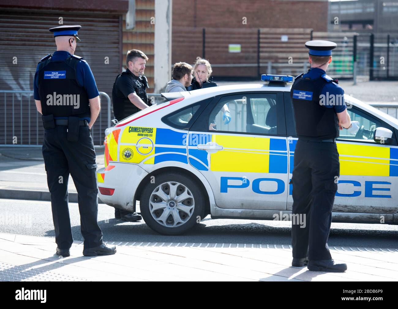 A police patrol with Community Support Officers negotiate with a man and put him in a patrol car in Weston-super-Mare during the Coronavirus lockdown Stock Photo