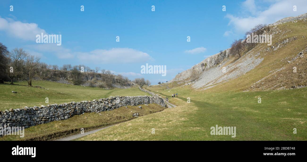 Springtime view of the countryside near Feizor in the Yorkshire Dales with walkers on a farm track and broad green footpath Stock Photo