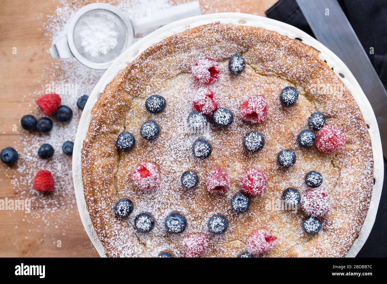 Flat lay of cake with with fresh colourful berries Stock Photo
