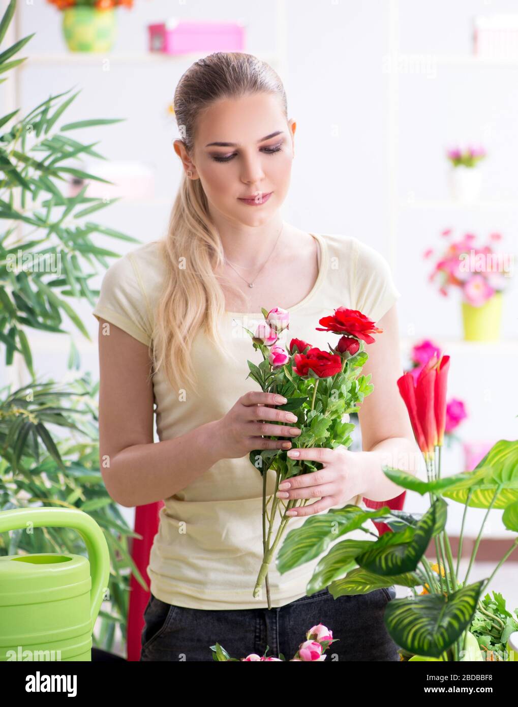 The young woman watering plants in her garden Stock Photo - Alamy