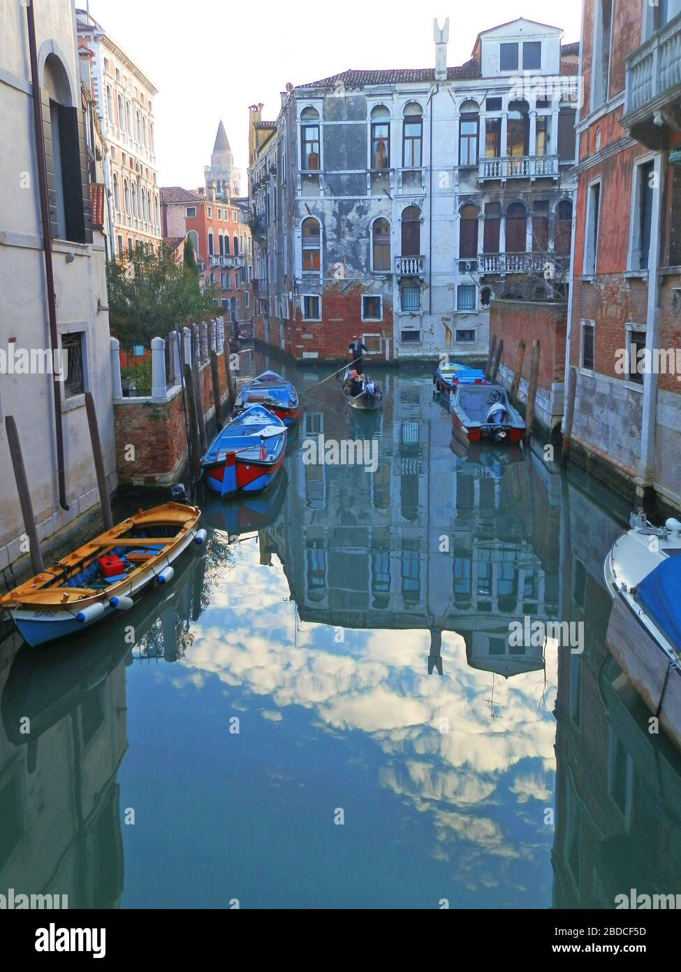 Colorful buildings, sky and clouds reflecting in Venetian canal Stock Photo