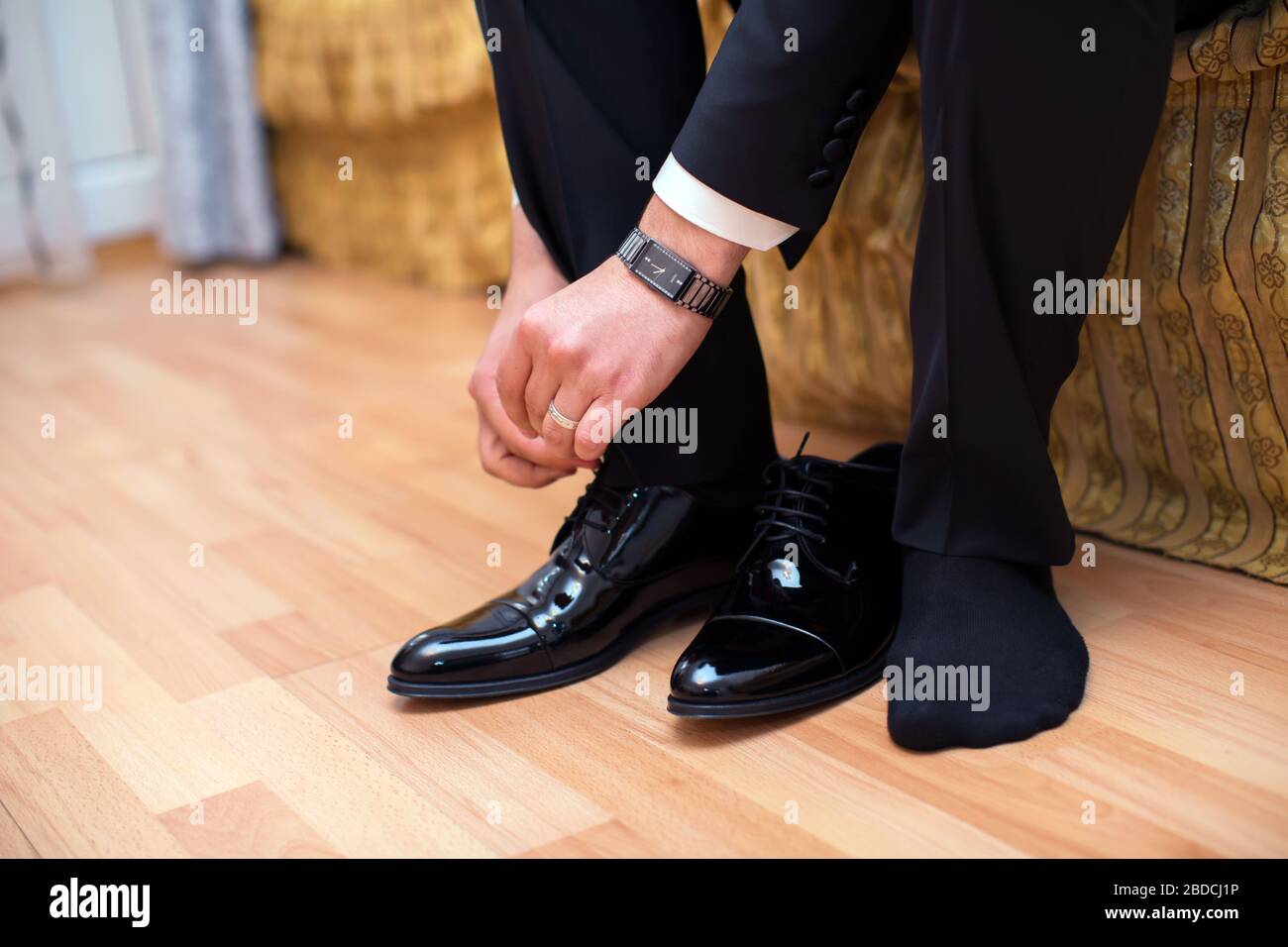 Closeup view of male hands lacing beautiful elegant shoes. wedding day ...