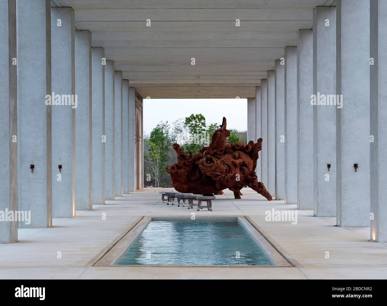 Colonnade with open air pool hall and  large sculpture beyond. Plantel Matilde, Yucatan, Mexico. Architect: Javier Marín and Arcadio Marín, 2020. Stock Photo