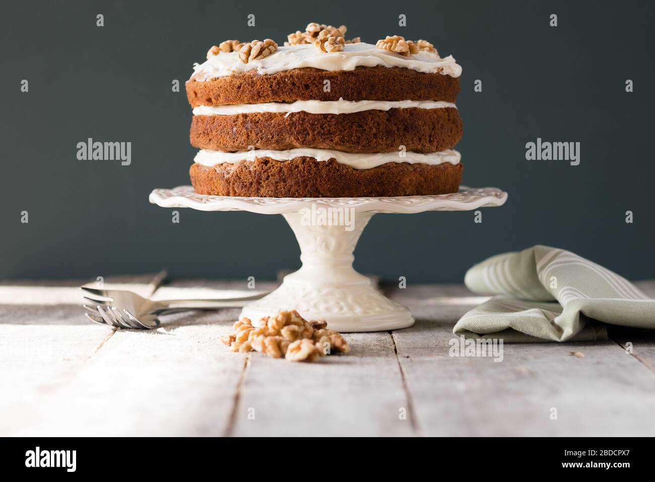 Three tier carrot cake with frosting on cake stand Stock Photo